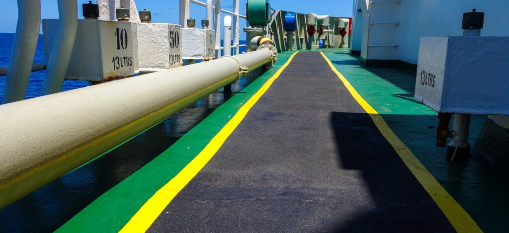 Coated ship deck walkway with green and yellow safety lines